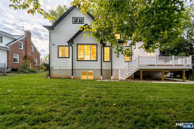 back of property with a wooden deck, a lawn, and central air condition unit