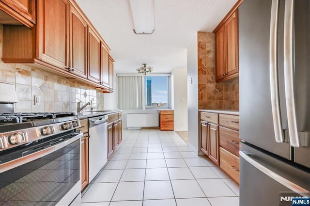 kitchen featuring light tile patterned flooring, stainless steel appliances, sink, and backsplash