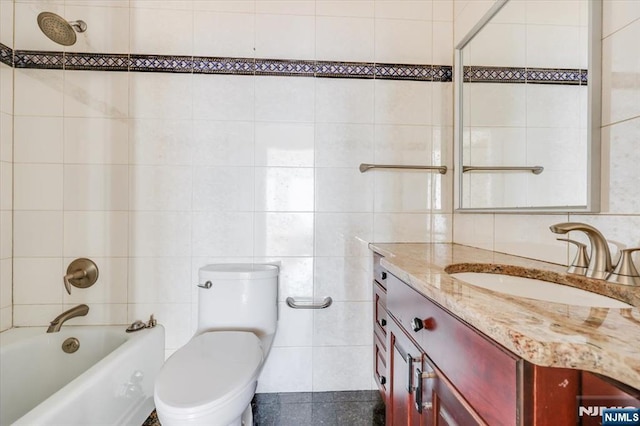 full bathroom with vanity, tub / shower combination, tile walls, and toilet