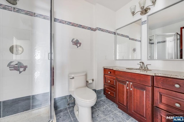 bathroom featuring tile patterned floors, toilet, an enclosed shower, tile walls, and vanity