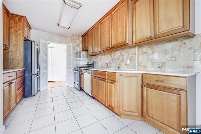 kitchen featuring stainless steel appliances, sink, decorative backsplash, and light tile patterned floors