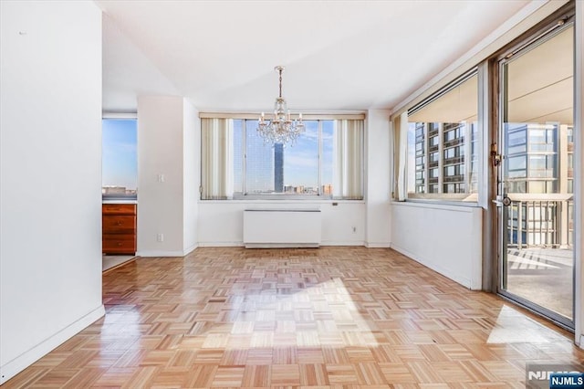 unfurnished dining area featuring a chandelier and light parquet flooring