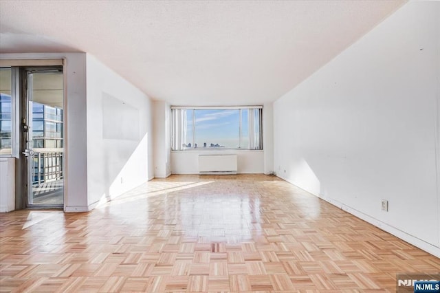 interior space with radiator heating unit and light parquet floors