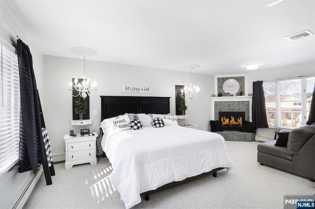 carpeted bedroom with a tile fireplace, a baseboard radiator, and an inviting chandelier