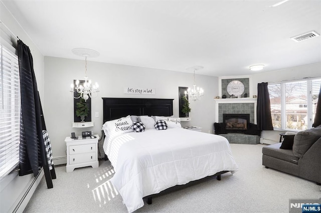 carpeted bedroom featuring a notable chandelier, a tile fireplace, and baseboard heating