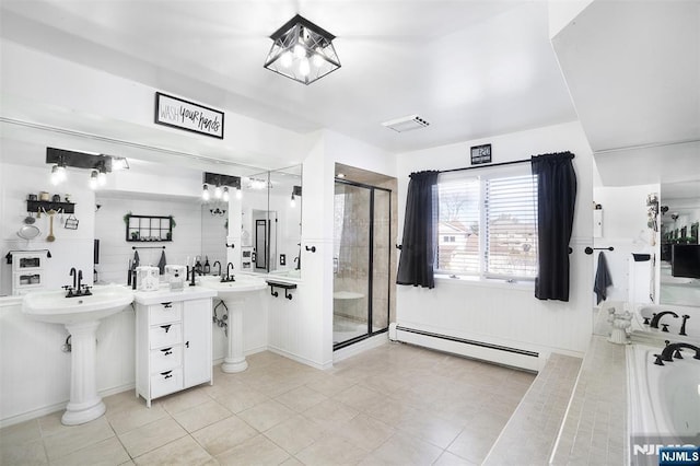 bathroom featuring an enclosed shower, a baseboard heating unit, tile patterned floors, and double sink