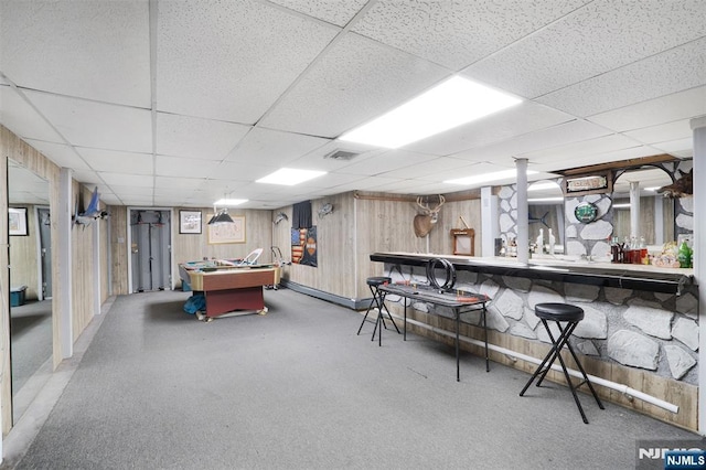 playroom with bar, pool table, a paneled ceiling, and wooden walls