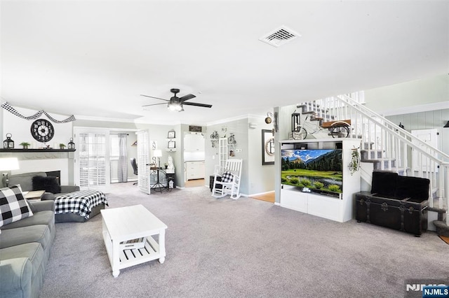 carpeted living room with crown molding and ceiling fan