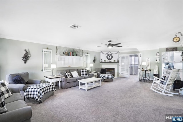 living room with ceiling fan, ornamental molding, and carpet floors