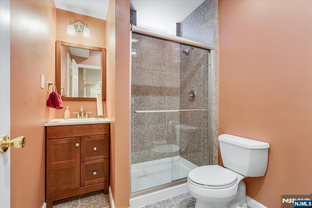 bathroom with tile patterned flooring, toilet, vanity, and walk in shower