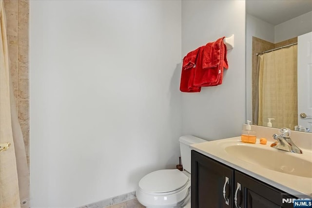 bathroom with vanity, curtained shower, and toilet