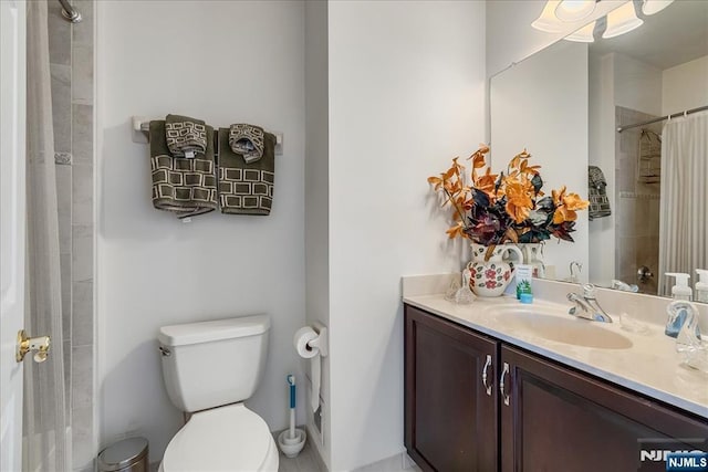 bathroom featuring vanity, toilet, and walk in shower