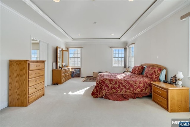 bedroom with a raised ceiling, crown molding, light carpet, and multiple windows