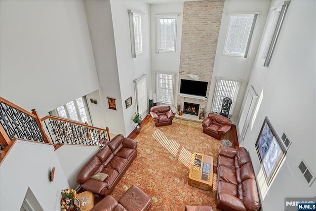 living room with a large fireplace and a high ceiling