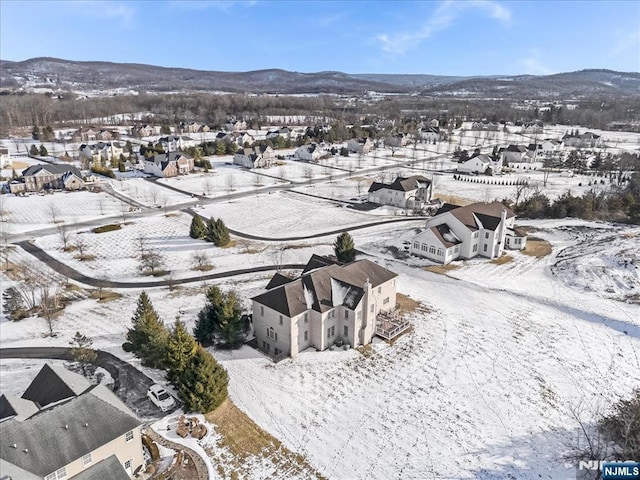 snowy aerial view featuring a mountain view