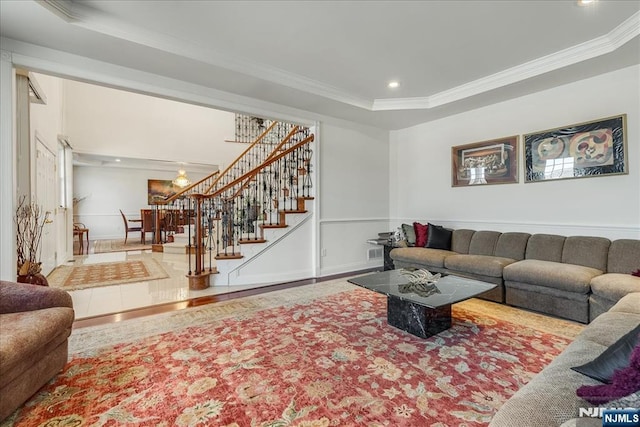 living room with crown molding and a raised ceiling