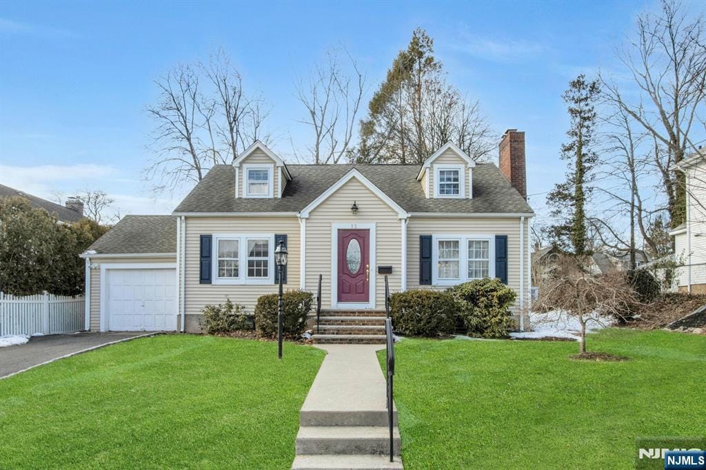 cape cod home featuring a garage and a front yard