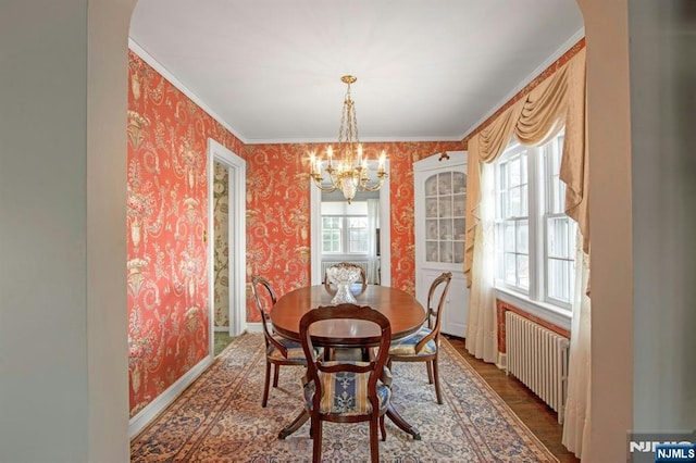 dining area featuring an inviting chandelier, crown molding, radiator heating unit, and wood-type flooring