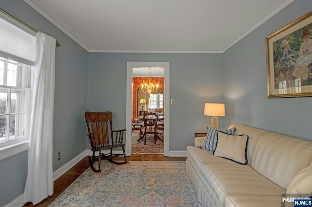 living room with hardwood / wood-style flooring, ornamental molding, and a chandelier