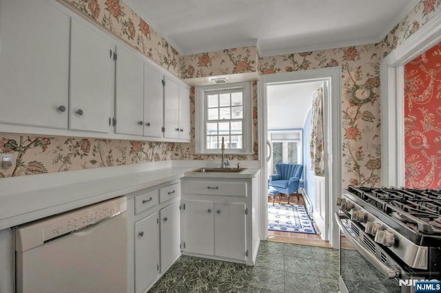 kitchen with stainless steel gas range oven, sink, white cabinets, and white dishwasher