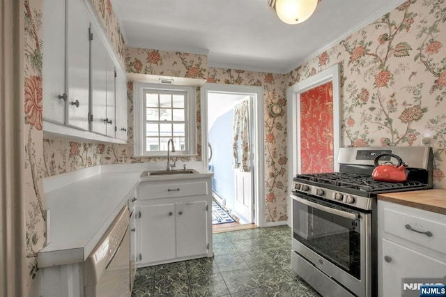 kitchen featuring sink, white cabinetry, a baseboard heating unit, white dishwasher, and stainless steel range with gas cooktop