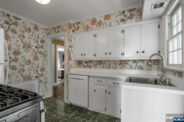 kitchen featuring sink, white cabinets, white dishwasher, stainless steel gas range oven, and crown molding