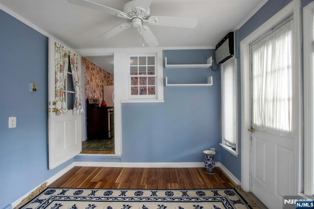 entryway featuring hardwood / wood-style flooring, ceiling fan, and a wall unit AC