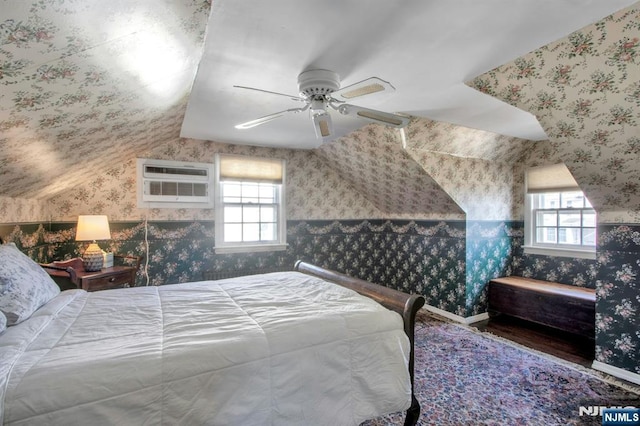 bedroom with multiple windows, vaulted ceiling, an AC wall unit, and ceiling fan