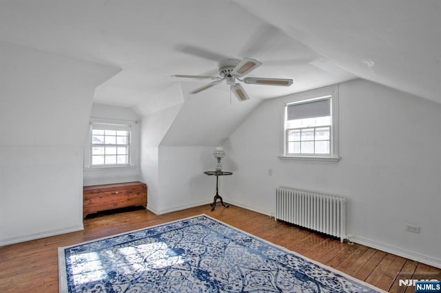 additional living space featuring ceiling fan, lofted ceiling, radiator heating unit, and hardwood / wood-style floors