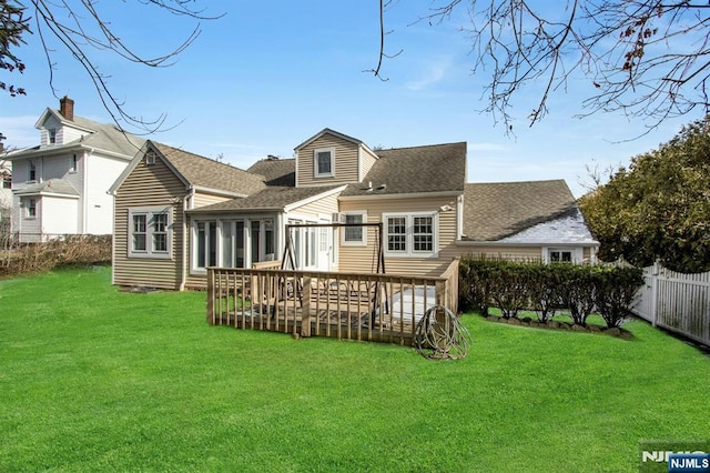 back of house featuring a yard and a deck