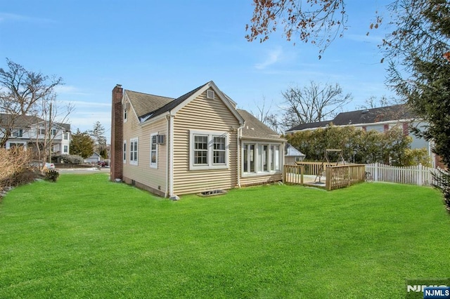 rear view of house featuring a yard and a deck