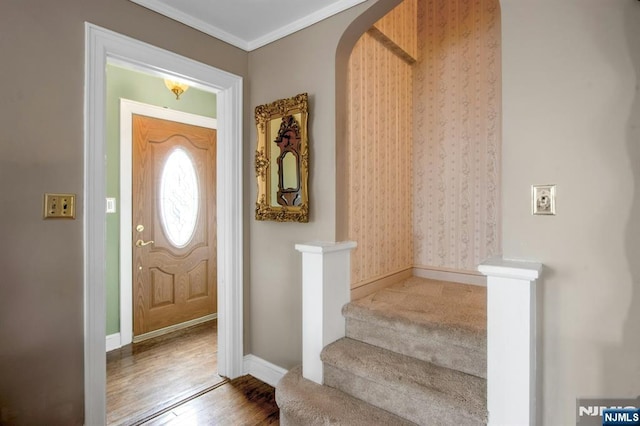 foyer with wood-type flooring and ornamental molding