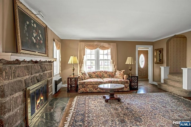 living room with ornamental molding, a fireplace, and dark hardwood / wood-style flooring