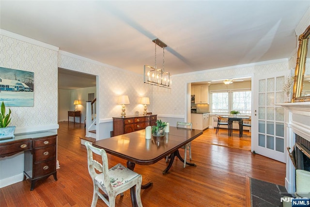 dining space featuring an inviting chandelier, ornamental molding, and hardwood / wood-style floors