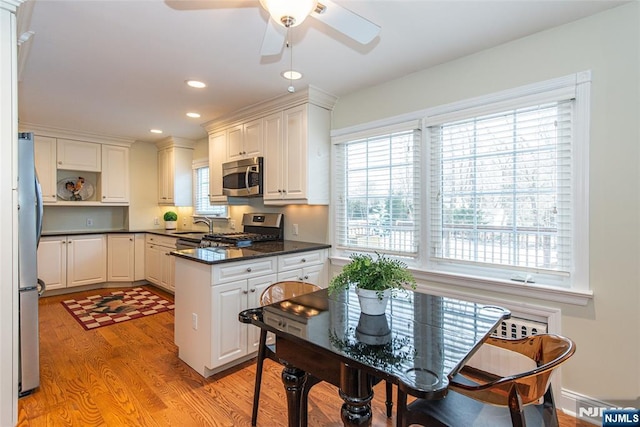 kitchen featuring white cabinetry, appliances with stainless steel finishes, sink, and light hardwood / wood-style flooring