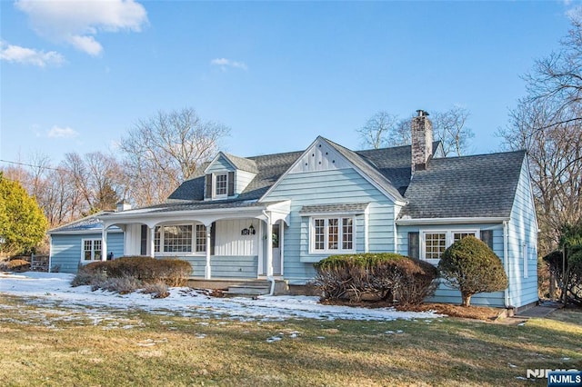 cape cod home with a yard and covered porch