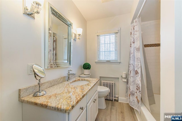 full bathroom with toilet, wood-type flooring, vanity, radiator, and shower / bath combo with shower curtain