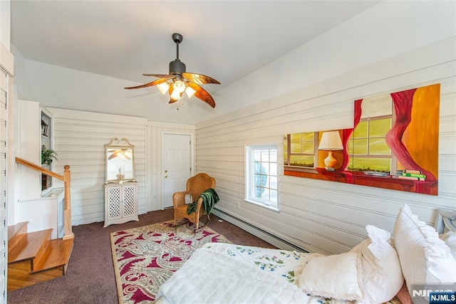 bedroom with ceiling fan, carpet flooring, baseboard heating, and wood walls