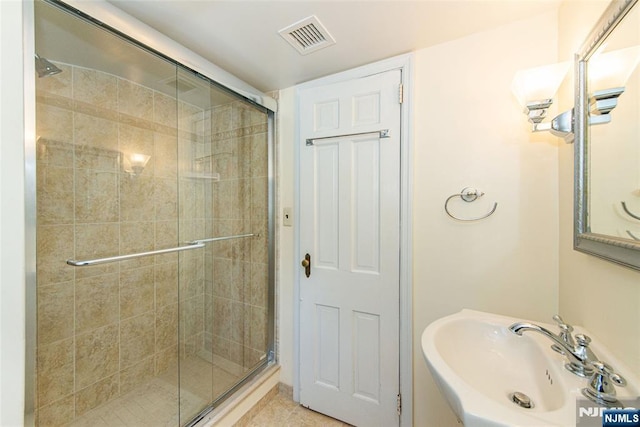 bathroom with tile patterned flooring, sink, and a shower with shower door