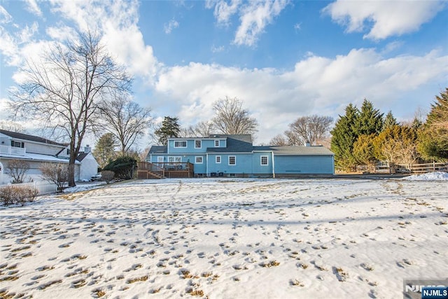 snow covered property featuring a wooden deck