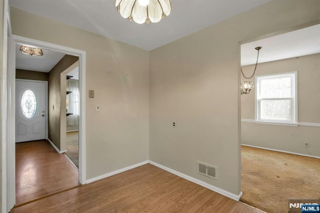 entryway featuring an inviting chandelier and hardwood / wood-style flooring