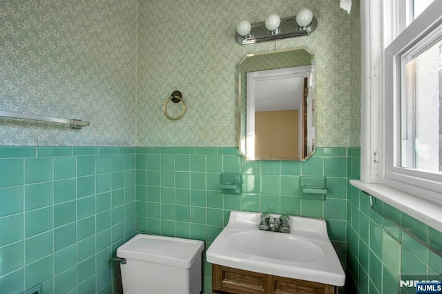 bathroom with vanity, toilet, and a wealth of natural light