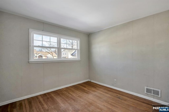 unfurnished room featuring wood-type flooring and ornamental molding