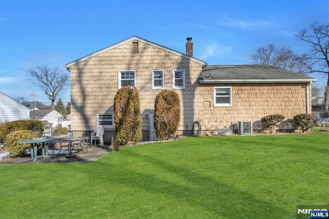 rear view of house with a yard and a patio