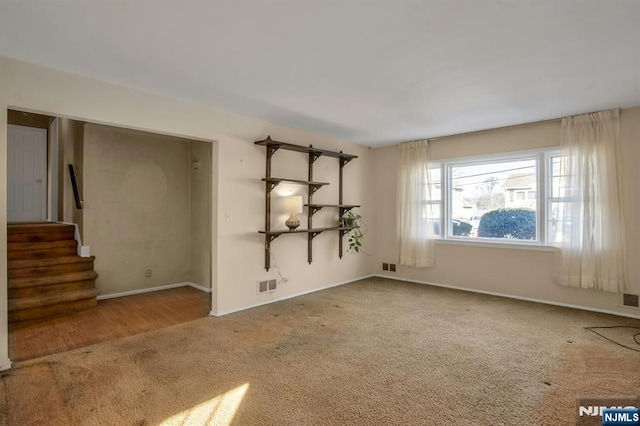 unfurnished room featuring light carpet