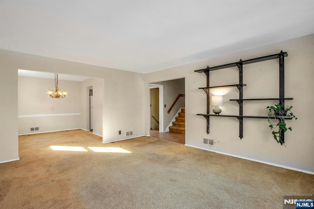 spare room with light carpet and a notable chandelier