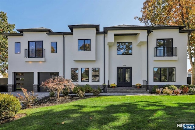 back of house with a garage, a yard, and french doors