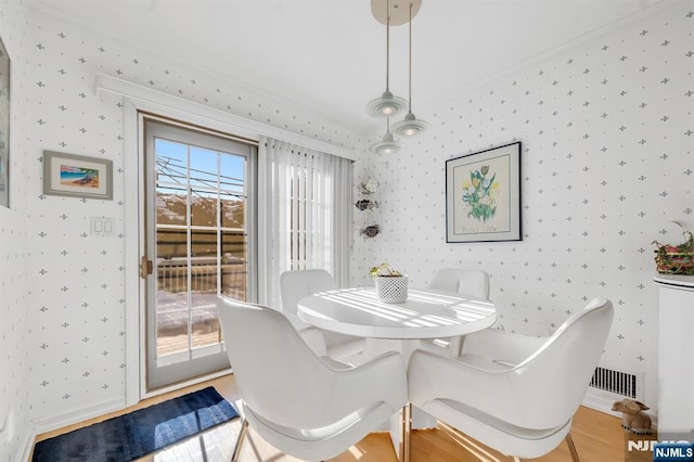 dining area featuring crown molding and hardwood / wood-style flooring