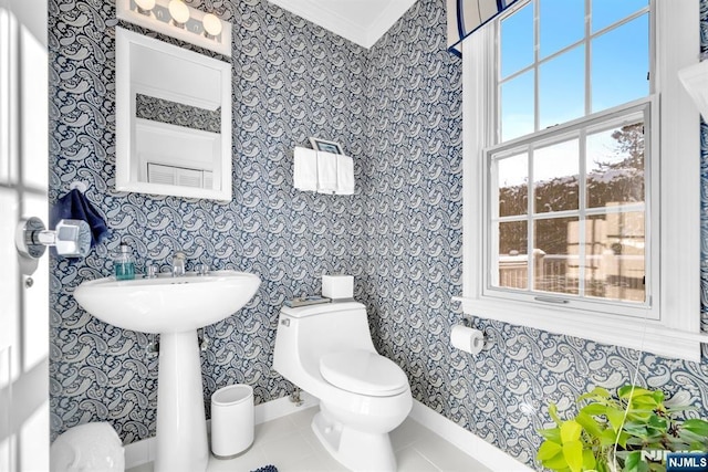 bathroom featuring crown molding, tile patterned floors, and toilet