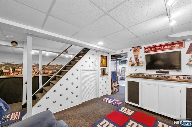 carpeted living room with a drop ceiling